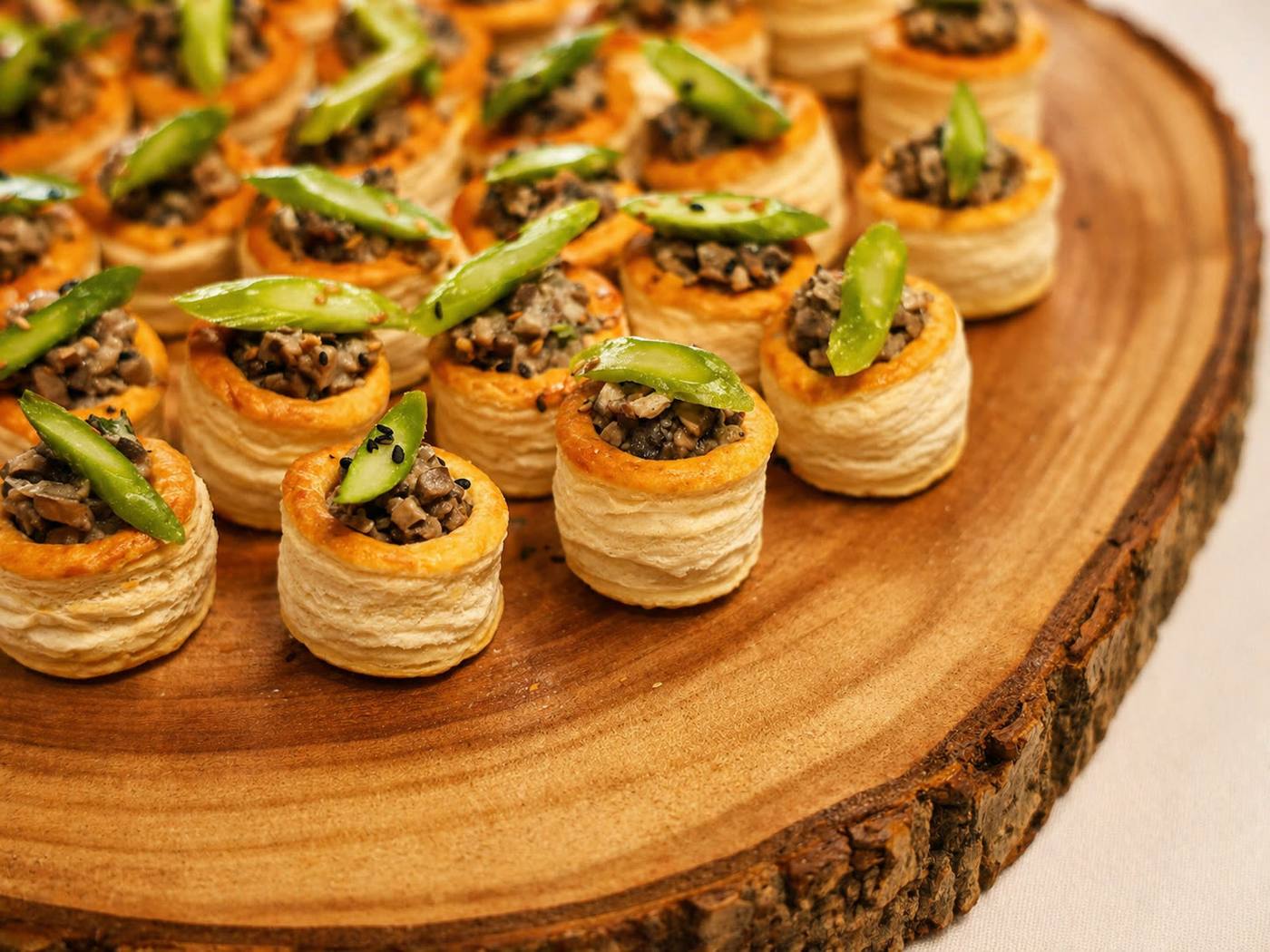 Vol-au-vents de cogumelos com espargos verdes em tábua de madeira rústica