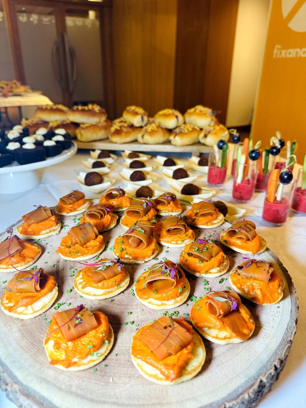 Blinis com creme de cenoura e salmão fumado em evento corporativo